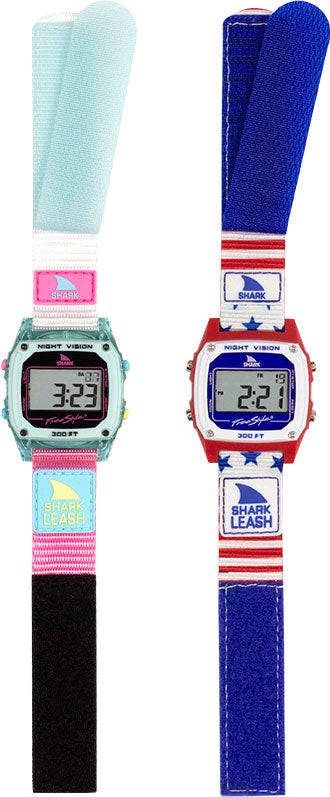 Two Shark watches featuring colorful straps, one with a blue and red design and the other with a pink and teal design, both labeled 'SHARK LEASH'.