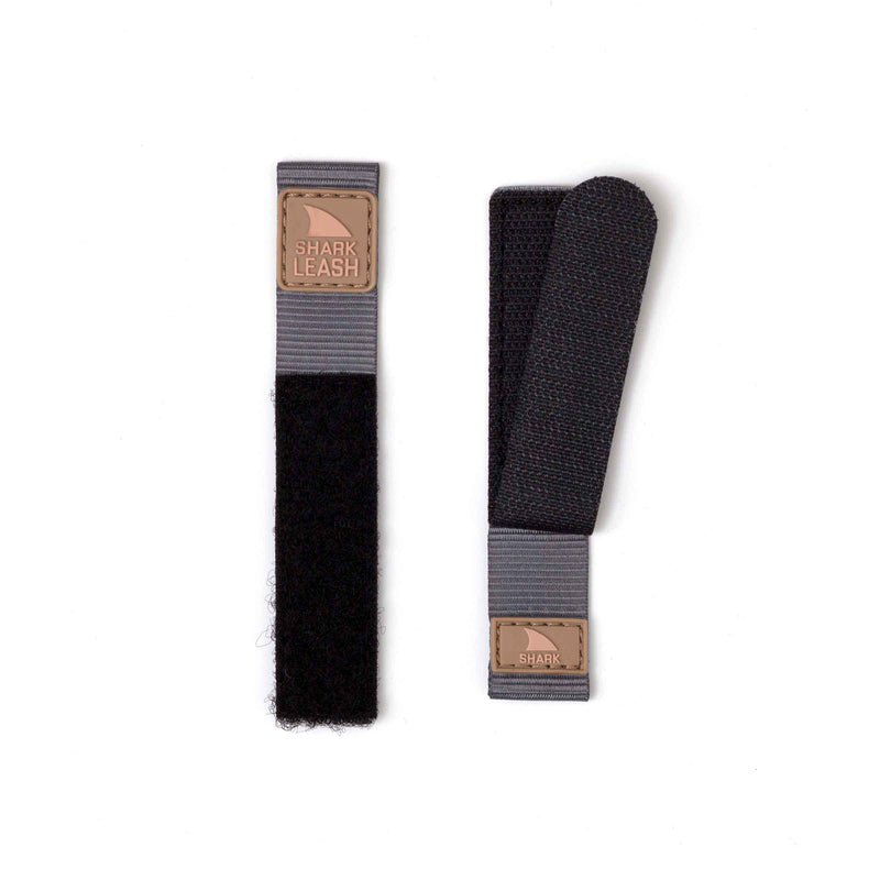 Two Freestyle STRAP KIT - LEASH - SAHARA black and grey straps with leather tags displayed on a white surface.