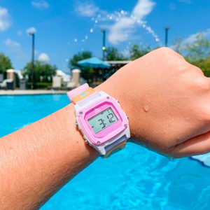 A hand wears a Freestyle SHARK CLASSIC LEASH BLUE TIE DYE watch by a sunny blue pool.