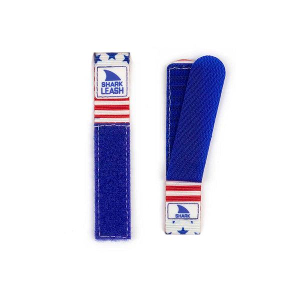 Two straps from the STRAP KIT - LEASH - STARS & STRIPES collection for Freestyle: one blue shark leash strap folded, and another open, featuring red and white stars.
