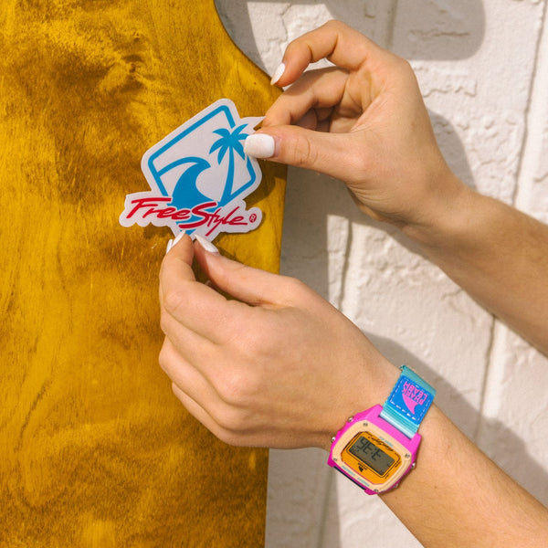 A person wearing a colorful Freestyle Shark Vibe watch adds a Freestyle Shark Vibe decal.