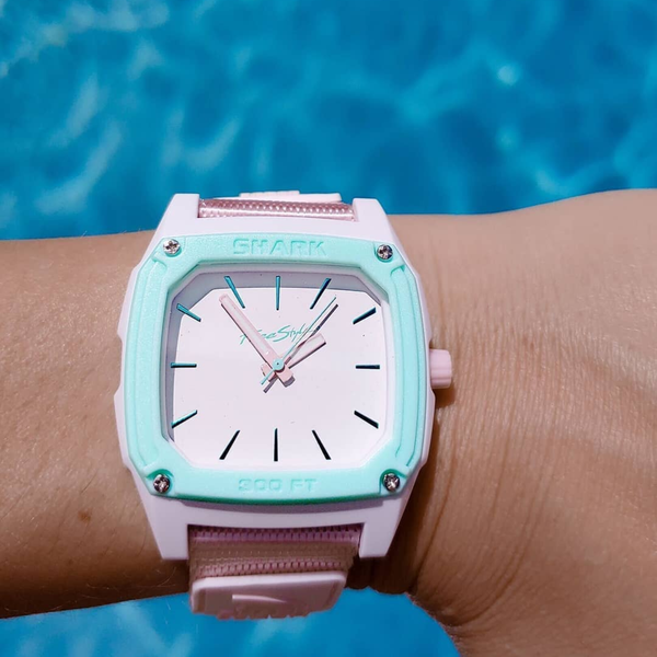 The Freestyle SHARK CLASSIC LEASH ANALOG SEAFOAM watch stands out, water-resistant, against the pool’s blue background.