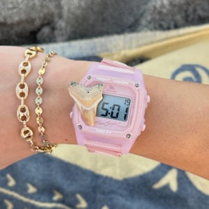 The Freestyle SHARK CLASSIC CLIP ROSE is a pink digital surf watch featuring a shark face, gold chain accents, and 100m water resistance.