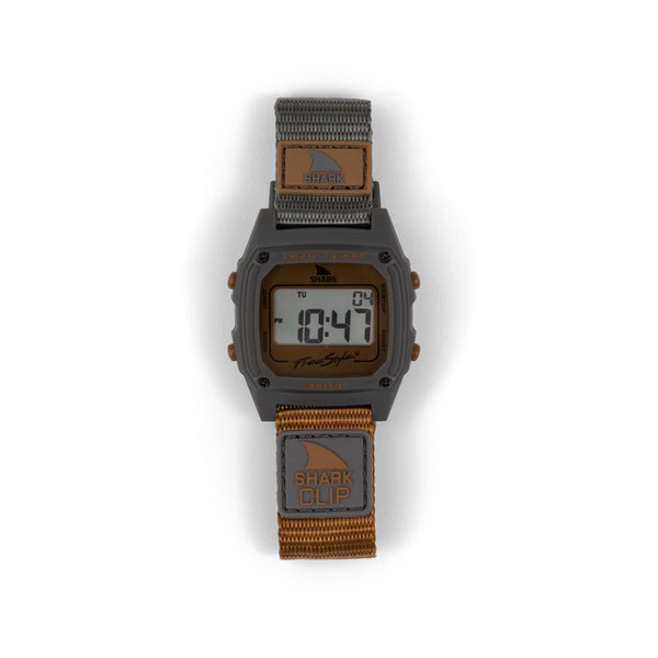 Freestyle SHARK CLASSIC CLIP MOJAVE: A digital watch with a brown nylon strap and gray face, displaying the time 10:47.
