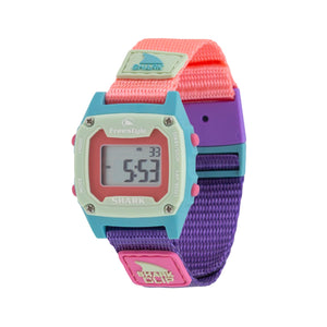 Freestyle SHARK MINI CLIP SEASCAPE: Mini digital watch with pastel face and pink, purple, and blue strap, display illuminated.