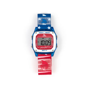 The Freestyle SHARK CLASSIC CLIP FINS & TAILS is a surf-style watch featuring a red, white, and blue strap and a rectangular face.