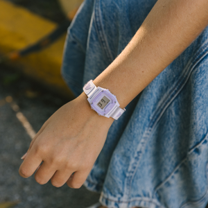 Someone wears a Freestyle SHARK MINI LEASH LILAC SPLASH watch and a blue denim skirt outside.
