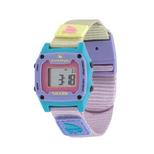 A Freestyle SHARK MINI CLIP LAVENDER TEA water-resistant watch with pastel strap displays a digital screen.