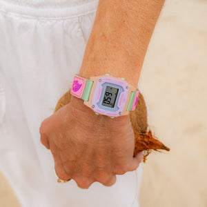 Person wearing a colorful digital watch with a white background
