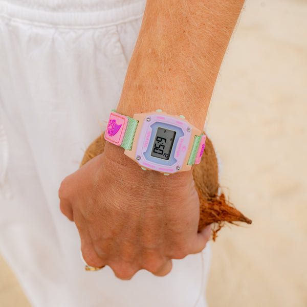 Person wearing a colorful digital watch with a white background