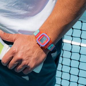 Person with a colorful digital watch on a tennis court