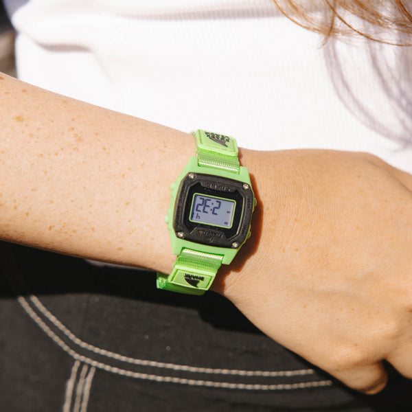 Person wearing a green digital watch 