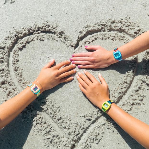 Hands in the sand around a heart