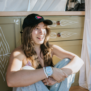 Model wearing the black Freestyle Dad Cap with the neon shark fin logo embroidered on the front.