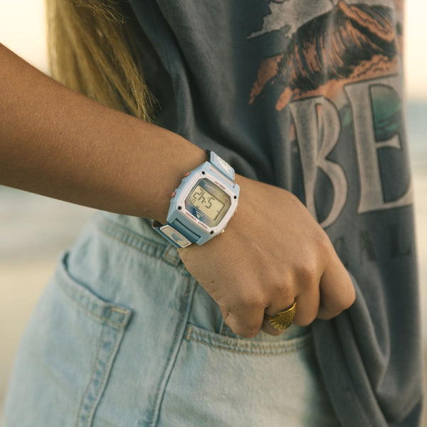 Person wearing the Freestyle Shark Clip watch with a blue-to-mauve gradient strap, styled casually near the beach.