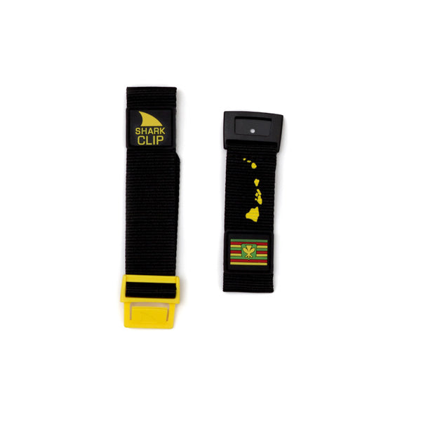 Two Freestyle Shark Classic Clip wristbands in black/yellow; left with Shark Clip Strap, right features Hawaii islands and flag.