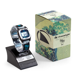 Freestyle LUKE DAVIS SIGNATURE SHARK CLASSIC CLIP WHITE WAVE watch displayed on stand beside a wave-patterned box.