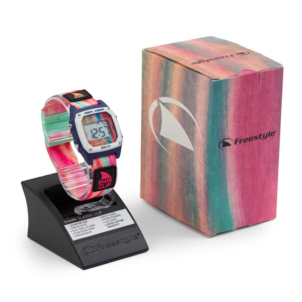 Freestyle SAGE ERICKSON SIGNATURE SHARK CLASSIC CLIP RAINBOW SORBET watch on stand beside its matching striped box.