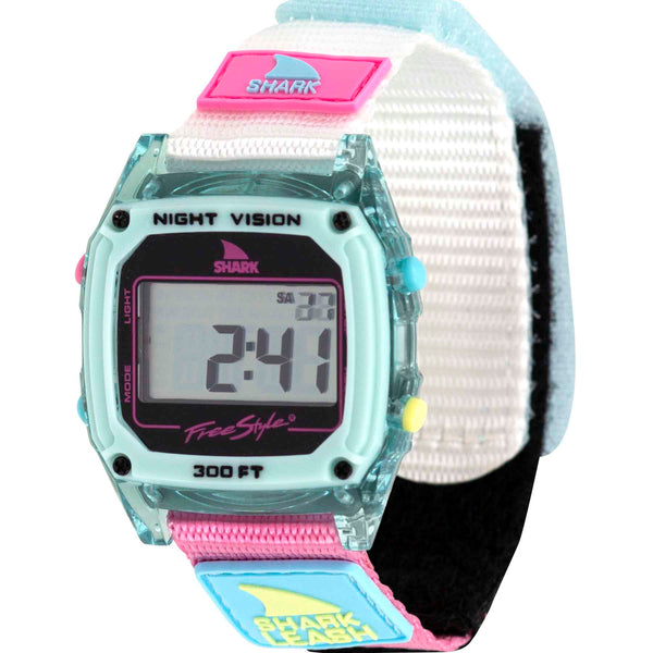 Embrace the retro vibe of the Freestyle Caroline Marks Signature Shark Classic Leash in Clear Blue Sky. This digital wristwatch features a grey face, teal casing with pink, white, and blue accents, and a colorful fabric strap. The display shows 2:41 and includes Night Vision and Shark text.