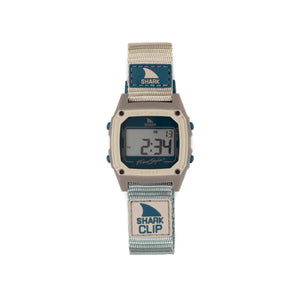 The Freestyle SHARK CLASSIC CLIP COOL SHORE is a digital wristwatch with a grey-blue strap, displaying numerals on its screen.