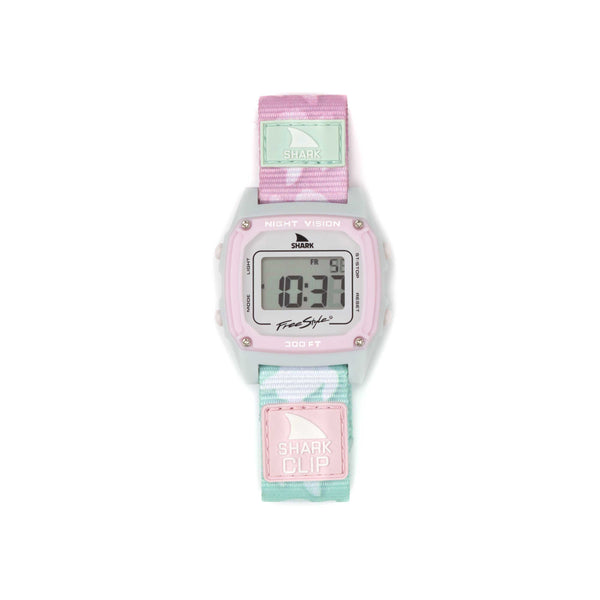 The Freestyle SHARK CLASSIC CLIP TWO TONE TURTLE digital wristwatch has a pink and green camo strap and a retro-futuristic design. The display shows FRI 10:31 and features NIGHT VISION, with 300 FT indicating its adventure-ready capabilities.