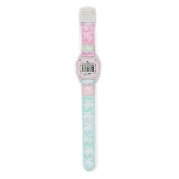 Freestyle SHARK CLASSIC CLIP TWO TONE TURTLE wristwatch with a square face displaying 11:16 and a pastel pink and teal strap adorned with white turtle patterns. The watch features a pink-outlined face and small side buttons, offering a retro-futuristic touch to your style.