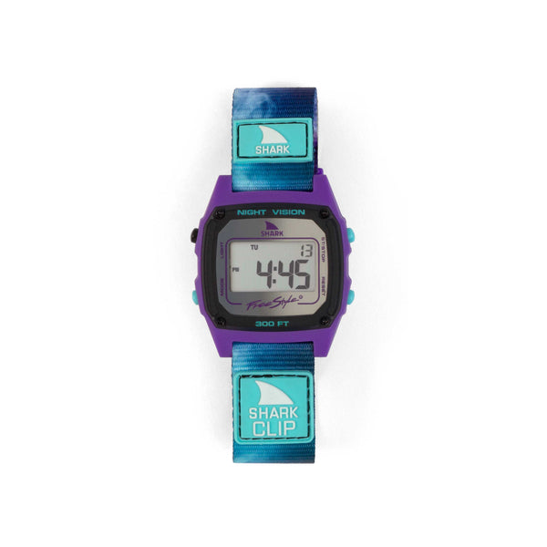Freestyle Amber Torrealba Signature Shark Classic Clip Reflection: Purple watch face with a blue strap, displaying 4:49. Features include Shark Clip, Night Vision, and comes with a Limited Lifetime Warranty.